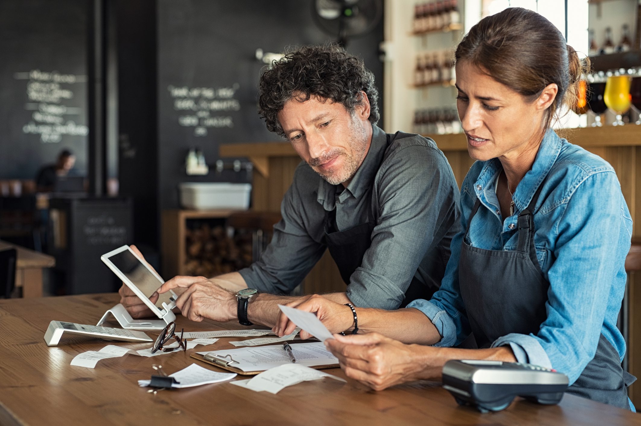 Two people reviewing documents at counter.