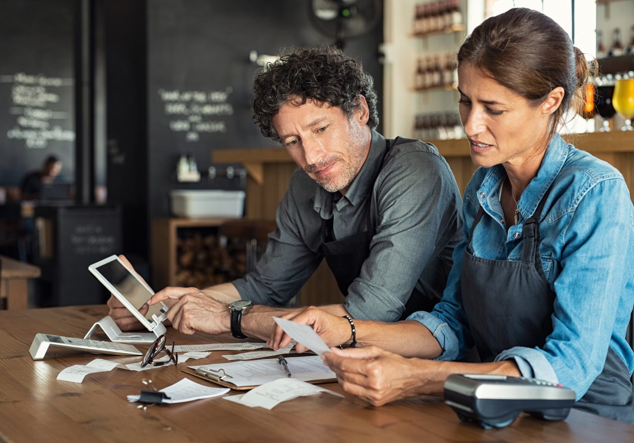 Two people reviewing documents at counter.